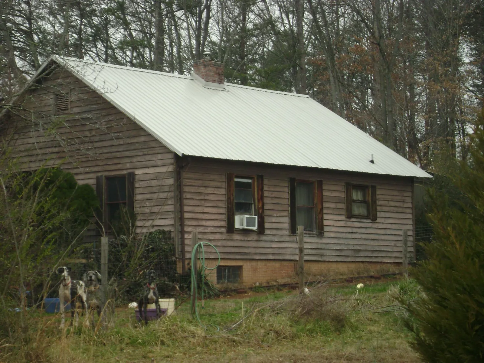 White metal roof on an old wood sided farmhouse, from a Metal Roof Installation job in Jordan